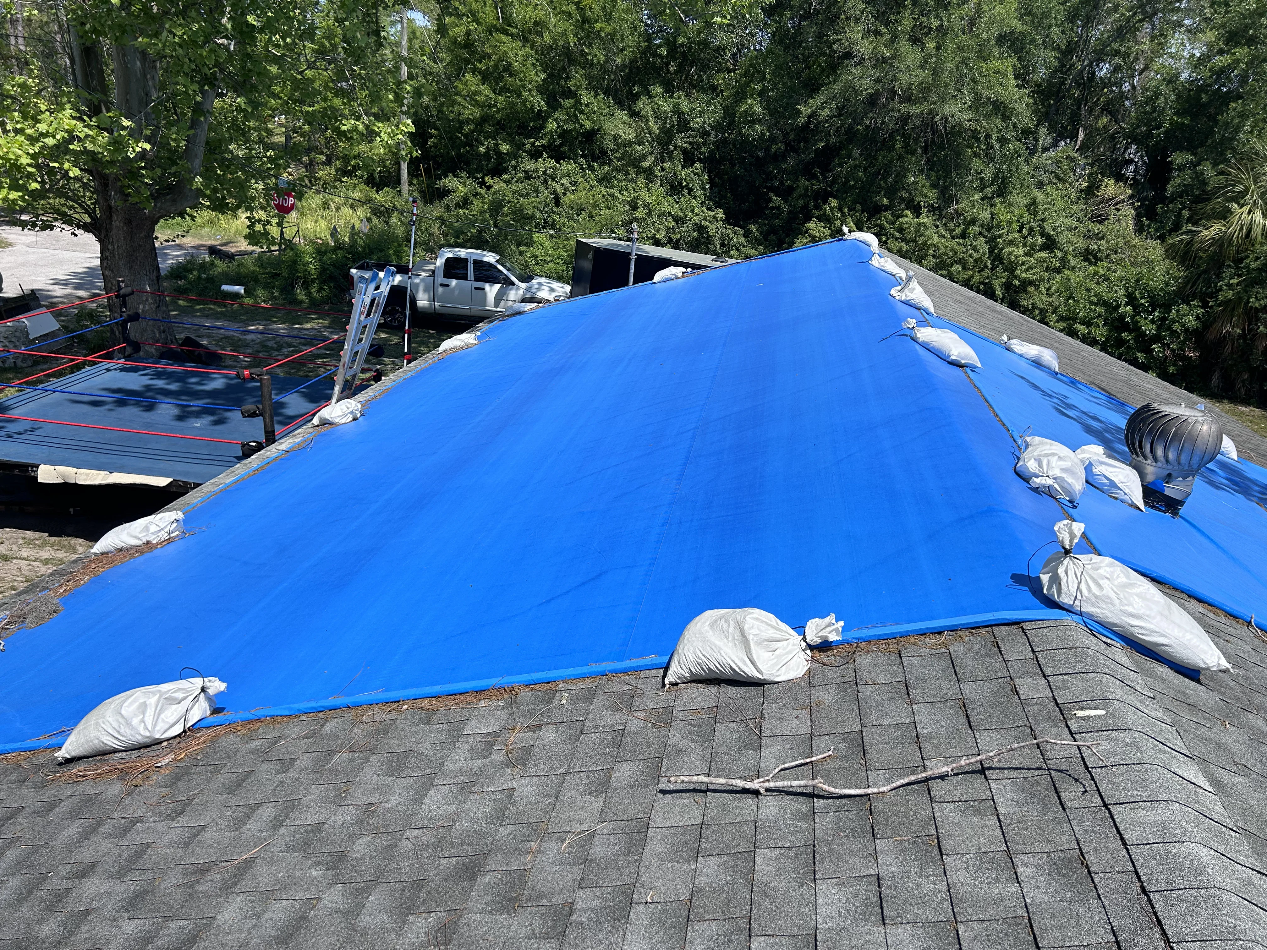 Tarping crew leader on phone call with field adjuster providing daily project update from site