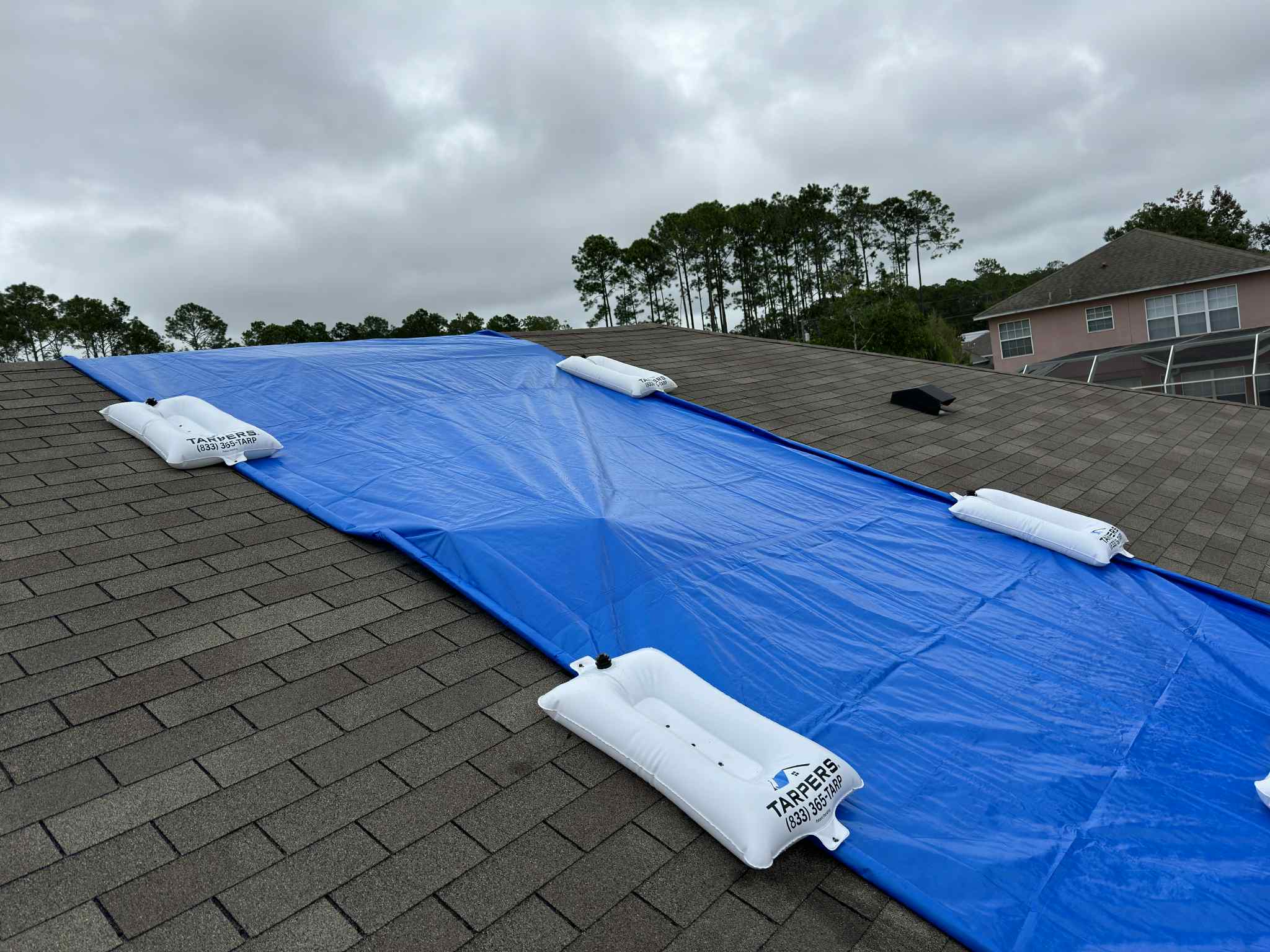 TarpBags securing a blue roof tarp without nails - non-destructive anchoring system